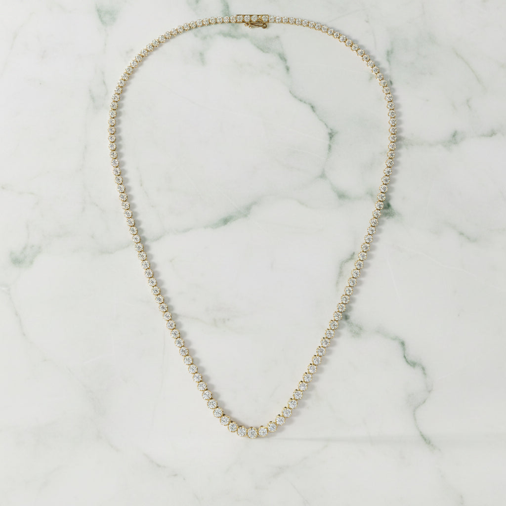 Gold necklace with small round stones on a light beige background