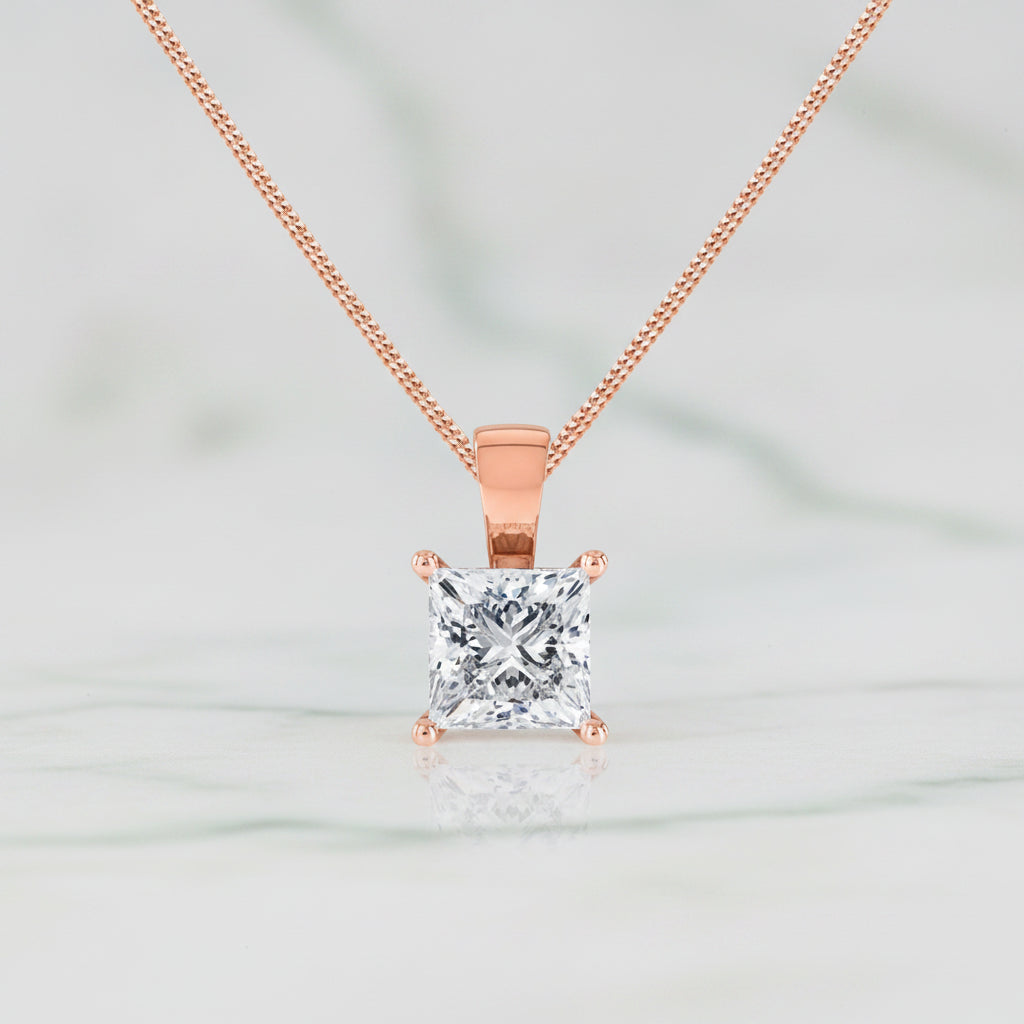 Rose gold necklace with a square-cut diamond pendant on a white background