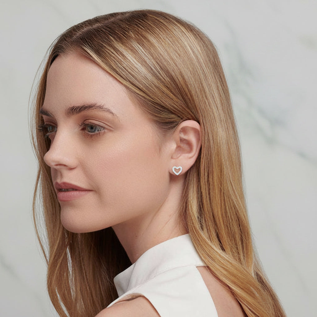 Woman wearing a small earring on a plain background