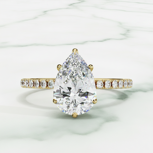 Diamond ring with a pear-shaped center stone on a white background